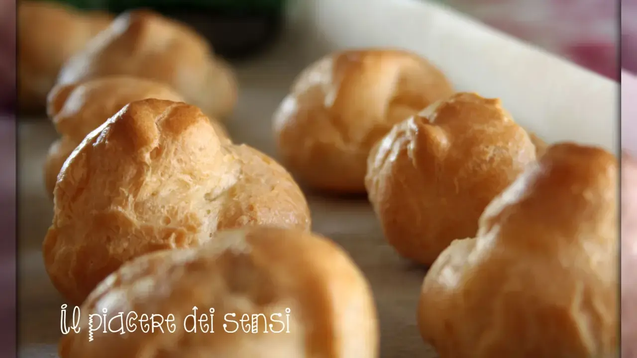 Bignè alla crema dorati e soffici, pronti per essere gustati. Un vero piacere per i sensi.