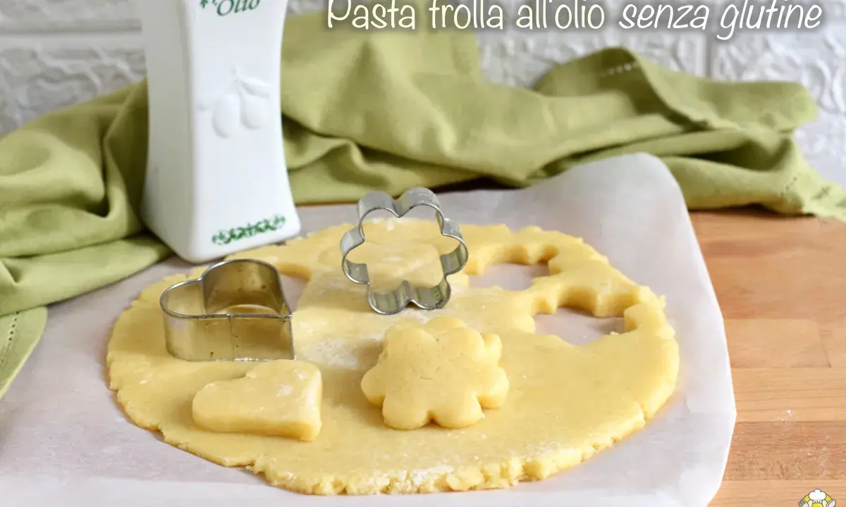 Pasta frolla all'olio senza glutine pronta per essere trasformata in biscotti con formine a cuore e fiore.