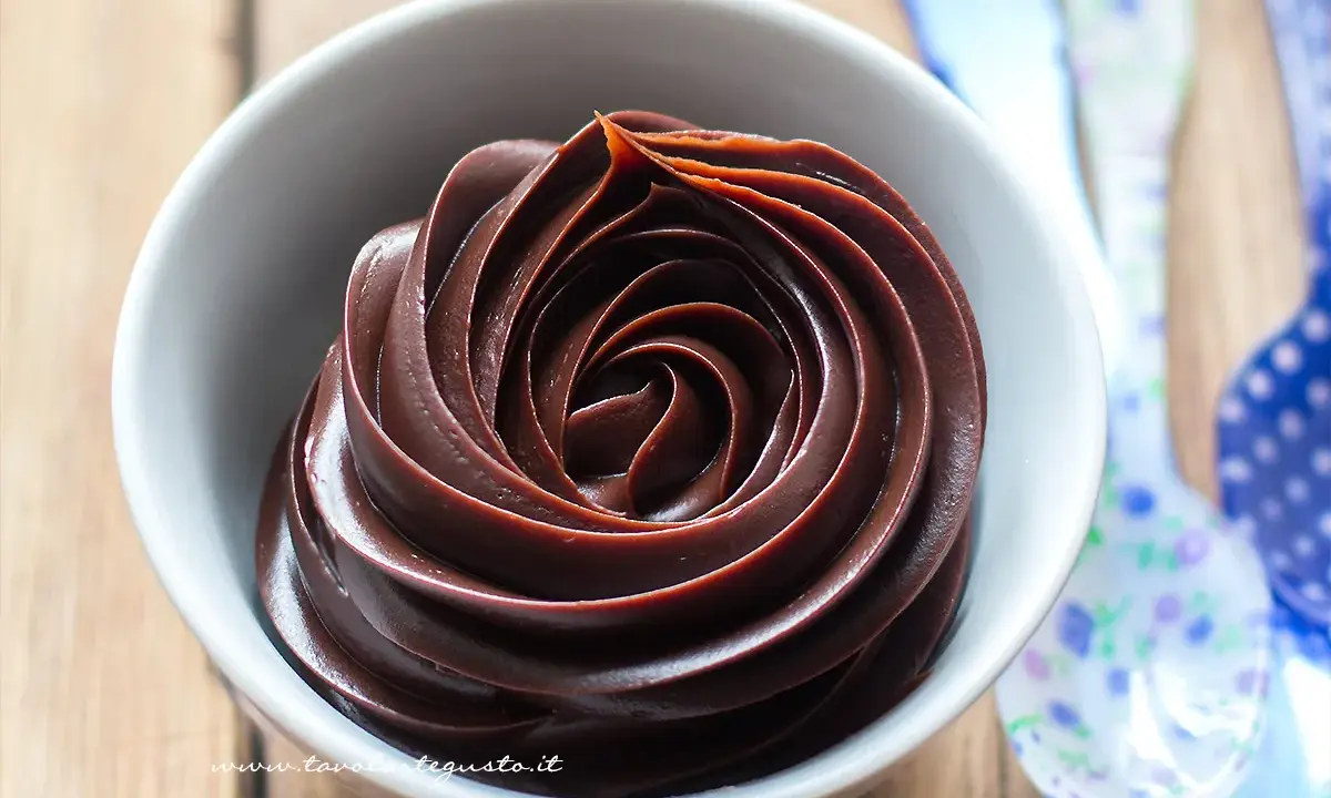 Una ciotola bianca piena di deliziosa crema al cioccolato, con un vortice perfetto.