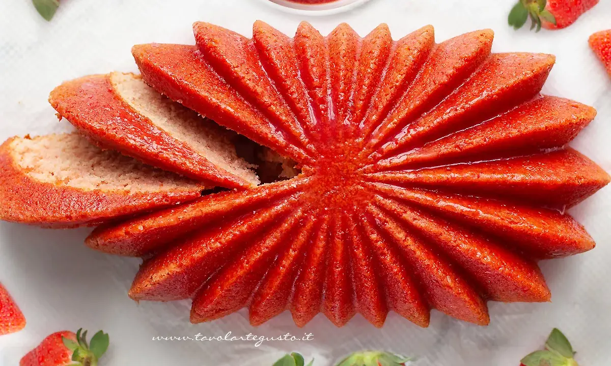 Delizioso dolce a forma di fiore, con fette di torta alle fragole che si aprono come petali. Fresche fragole circondano questo dolce, invitando a gustare la sua dolcezza.