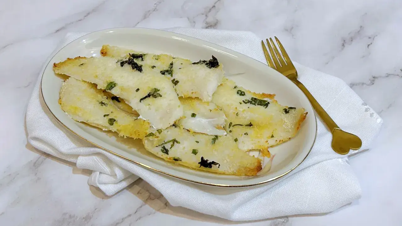 Delizioso merluzzo in friggitrice ad aria, croccante fuori e morbido dentro, guarnito con erbe aromatiche.