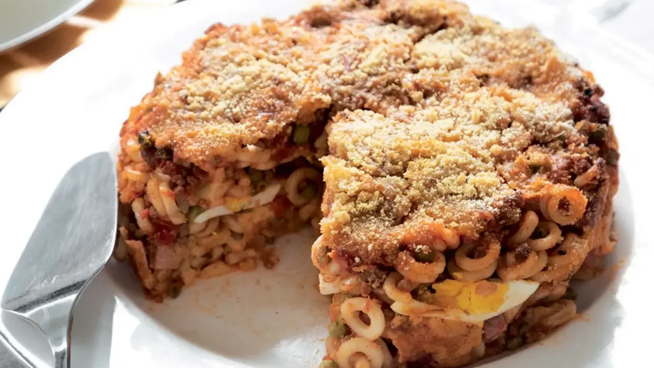 Un invitante anelletti al forno, con strati di pasta, ragù, piselli e uova sode, dorato e croccante in superficie.