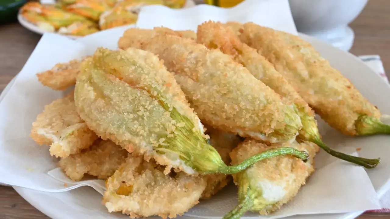 Fiori di zucca fritti, croccanti e dorati, preparati con una leggera pastella per fiori di zucca.