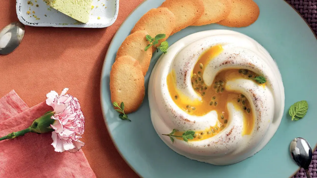 Deliziosa crema al latte con frutto della passione e biscotti, guarnita con menta. Un dolce invitante.