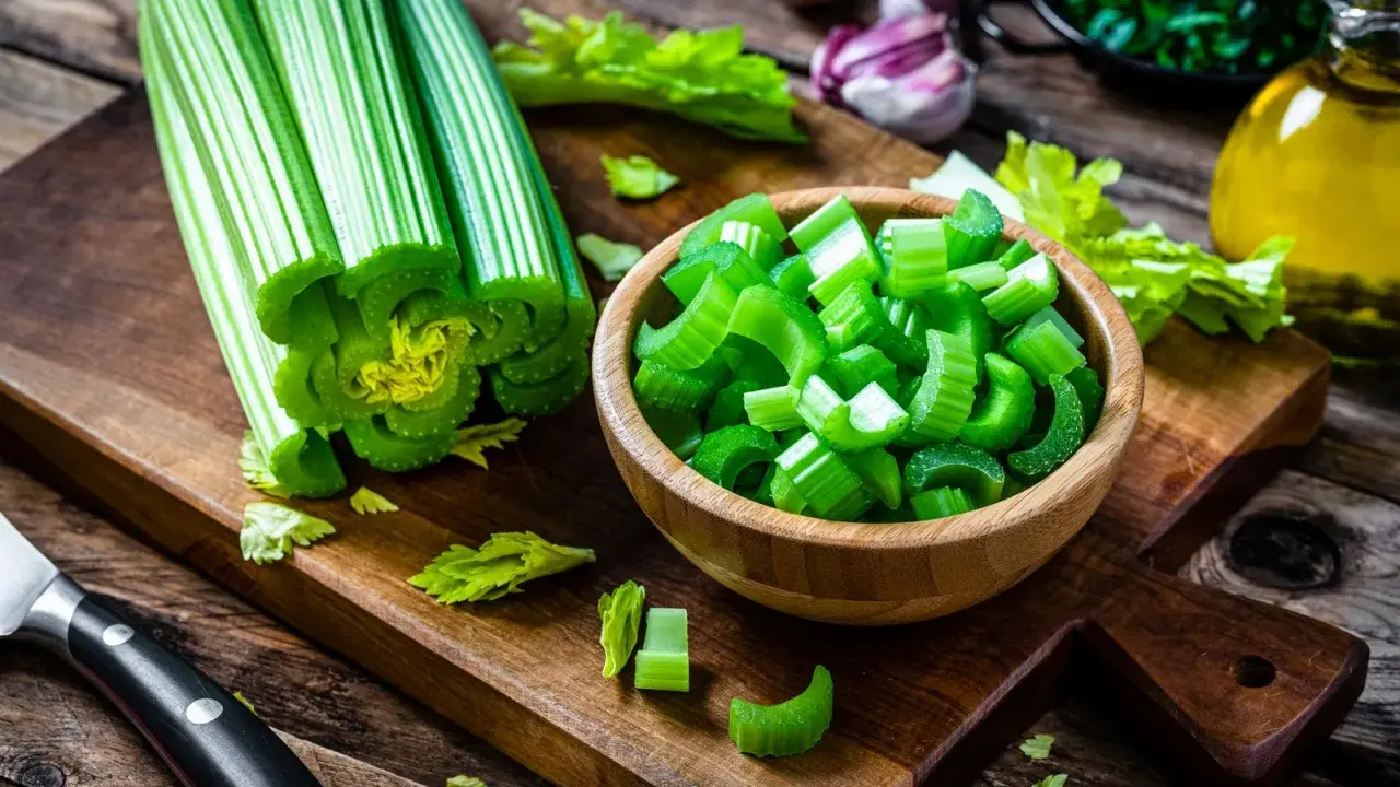 Sedano fresco, tagliato a pezzi in una ciotola, pronto per essere gustato. Verdure che non gonfiano la pancia, perfette per una dieta leggera e salutare.