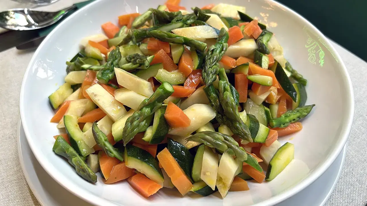 Un piatto invitante di verdure in padella: carote, zucchine e asparagi tagliati a pezzetti, cotti al punto giusto per un contorno sano e colorato.