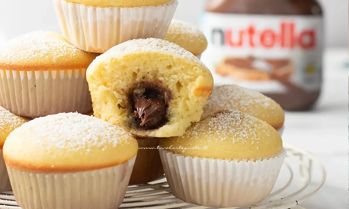Muffin semplici con cuore morbido di Nutella, spolverati di zucchero a velo. Una ricetta golosa e facile da preparare.
