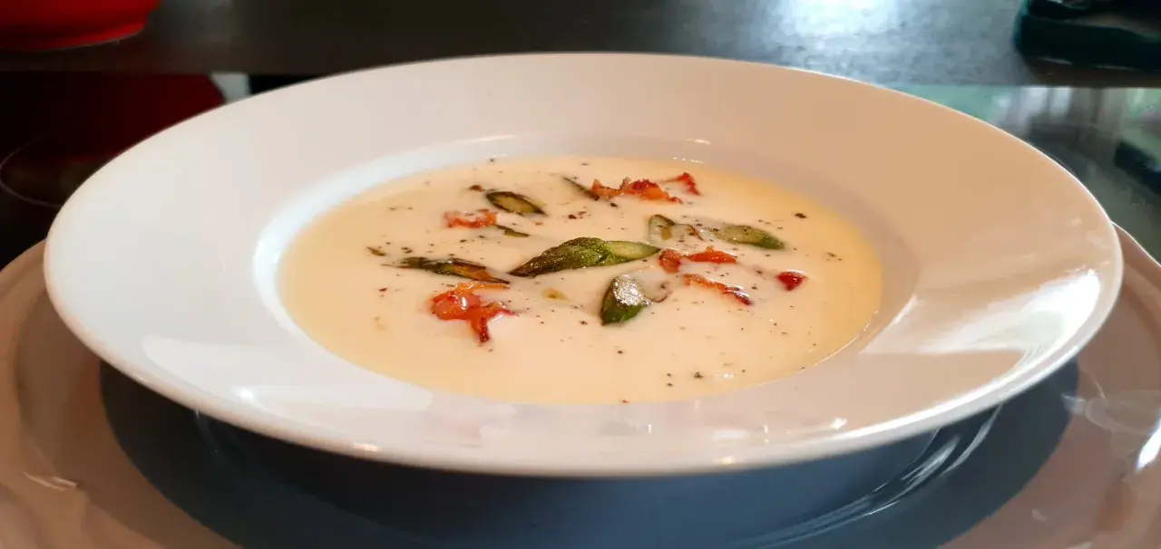 Una cremosa fonduta di pecorino con asparagi e pancetta croccante, un piatto che scalda il cuore.