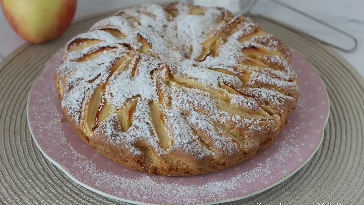 Una deliziosa torta di mele senza glutine, cosparsa di zucchero a velo, pronta per essere gustata.