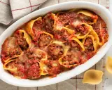 Conchiglioni ripieni al forno, un piatto invitante con pasta ripiena di carne, salsa di pomodoro e formaggio fuso, pronto per essere gustato.