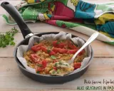 Alici gratinate in padella, un piatto semplice e gustoso con pomodorini e pangrattato, pronto per essere assaporato.