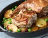 Coniglio in padella con patate arrosto e piselli, un piatto succulento e invitante.