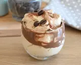 Deliziosa crema al caffè veloce in un bicchiere, guarnita con chicchi di caffè e cacao.