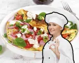 Chef sorridente mostra una deliziosa frittata di cipolle, pomodori e formaggio feta, guarnita con basilico fresco.