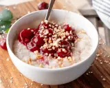Una ciotola di porridge con ciliegie e nocciole tritate, una deliziosa colazione senza zuccheri.