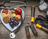 Stetoscopio, cuore di legno con 20 alimenti che alzano la pressione, attrezzi per fitness e scarpe da corsa.