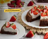 Una crostata morbida al cioccolato, guarnita con panna e fragole fresche, è la ricetta della felicità.