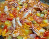 Totani in umido con pomodoro, patate e olive, un piatto saporito e colorato, pronto per essere gustato.