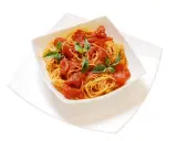 Un invitante piatto di spaghetti al pomodoro fresco, guarnito con foglie di basilico verde brillante.