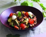 Insalata di farro estiva con verdure grigliate, pomodorini, mozzarelline e basilico, un piatto fresco e colorato.