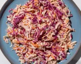 Insalata colorata con cavolo cappuccio rosso, carote e semi di senape, condita con una salsa cremosa.
