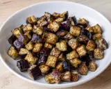 Melanzane a cubetti, cotte in friggitrice ad aria, dorate e saporite, pronte per essere gustate.