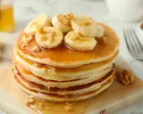 Pancakes leggeri con banane e noci, una deliziosa ricetta pancake light, guarniti con sciroppo d'acero e miele.