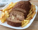 Polpettone ripieno di prosciutto e formaggio, cotto in friggitrice ad aria, servito con patatine fritte croccanti.