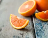 Arance fresche tagliate a spicchi su un tavolo di legno. Quante arance si possono mangiare al giorno? Dipende dal tuo fabbisogno di vitamina C.