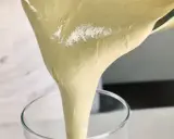 Versando una soffice pate a bombe in un bicchiere trasparente, pronta per una deliziosa preparazione.