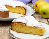 Una fetta di torta di mele invisibile, soffice e profumata, cosparsa di zucchero a velo. Accanto, mele fresche e un tovagliolo viola.