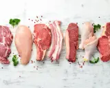 Varietà di carni: maiale, pollo e manzo. Carne bianca e rossa, con pepe rosa e prezzemolo.