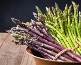 Mazzo di asparagi verdi e viola legati con spago, pronti per la cottura. Il tempo cottura asparagi varia a seconda della freschezza.