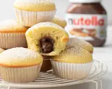 Muffin semplici con cuore morbido di Nutella, spolverati di zucchero a velo. Una ricetta golosa e facile da preparare.