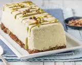Semifreddo al pistacchio decorato con glassa verde e granella di pistacchi, su base croccante.