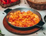 Uova strapazzate al pomodoro in padella, un piatto caldo e saporito, pronto per essere gustato.
