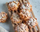 Dolci croccanti, simili a rose del deserto, ricoperti di fiocchi di mais e spolverati di zucchero a velo.