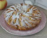 Una deliziosa torta di mele senza glutine, cosparsa di zucchero a velo, pronta per essere gustata.