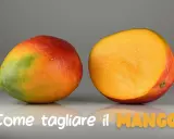 Un mango intero e uno tagliato a metà, mostrando la polpa succosa. Impara come si mangia il mango per gustarlo al meglio.