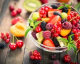 Ciotola di frutta fresca con fragole, lamponi, ribes, more e kiwi, un'ottima scelta di frutta con meno zuccheri.