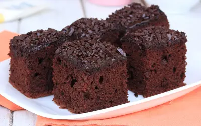Fette di torta al cioccolato, soffici e ricoperte di scaglie di cioccolato fondente, pronte per essere gustate.