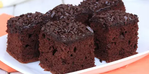 Fette di torta al cioccolato, soffici e ricoperte di scaglie di cioccolato fondente, pronte per essere gustate.