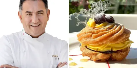 Chef sorridente accanto a una deliziosa zeppola di San Giuseppe, guarnita con crema pasticcera, amarene e decorazione di zucchero.