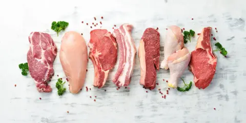Varietà di carni: maiale, pollo e manzo. Carne bianca e rossa, con pepe rosa e prezzemolo.