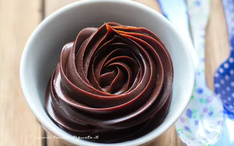Una ciotola bianca piena di deliziosa crema al cioccolato, con un vortice perfetto.