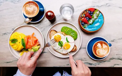 Colazione sana: uova, salmone, avocado, smoothie bowl e caffè. Ottimi esempi di colazione a basso indice glicemico per iniziare la giornata con energia.