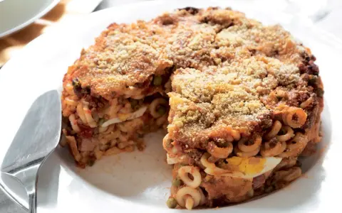 Un invitante anelletti al forno, con strati di pasta, ragù, piselli e uova sode, dorato e croccante in superficie.