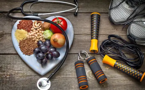 Stetoscopio, cuore di legno con 20 alimenti che alzano la pressione, attrezzi per fitness e scarpe da corsa.