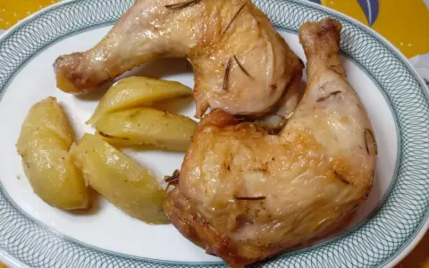 Cosce di pollo in friggitrice ad aria, dorate e succulente, servite con patate arrosto. Un piatto semplice e gustoso.