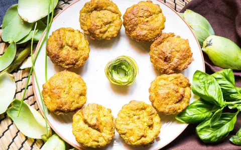 Muffin dorati, perfetti per una colazione proteica salata. Circondati da carciofi e basilico fresco, invitano a un pasto nutriente.